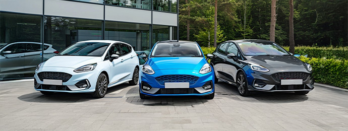 Ford Fiesta range including white, blue and grey hatchbacks parked outside a showroom