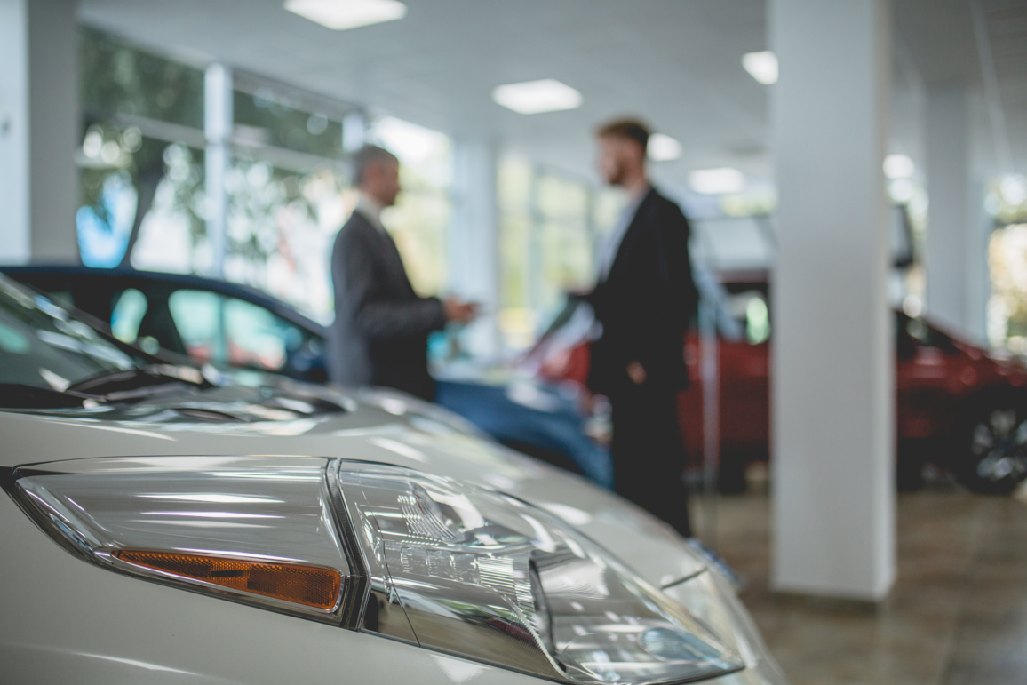 Auto showroom, dealer talking with buyer