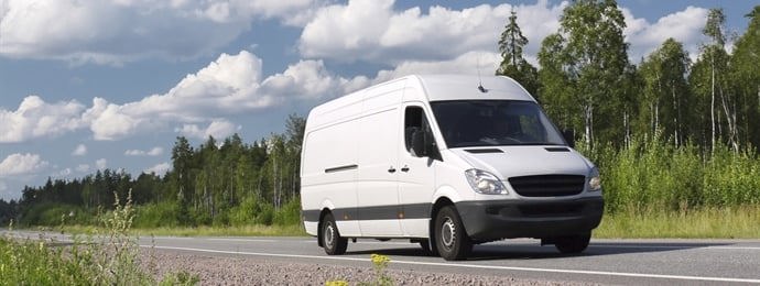 white van driving on the road